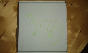 Auf dem Karton ist mit grünem Filzstift etwas gemalt, das durchaus als Brontosaurier durchgehen könnte.