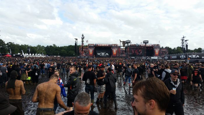 Zahlreiche, zum Teil schlammverkrustete Menschen feiern vor den Hauptbühnen des Wacken Open Airs 2017.